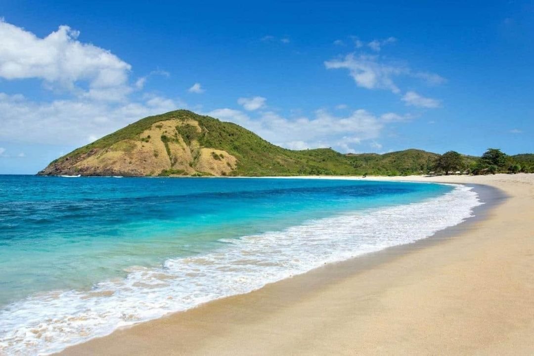 Pemandangan Pantai Kuta Lombok dengan pasir putih dan air laut biru di kawasan Mandalika